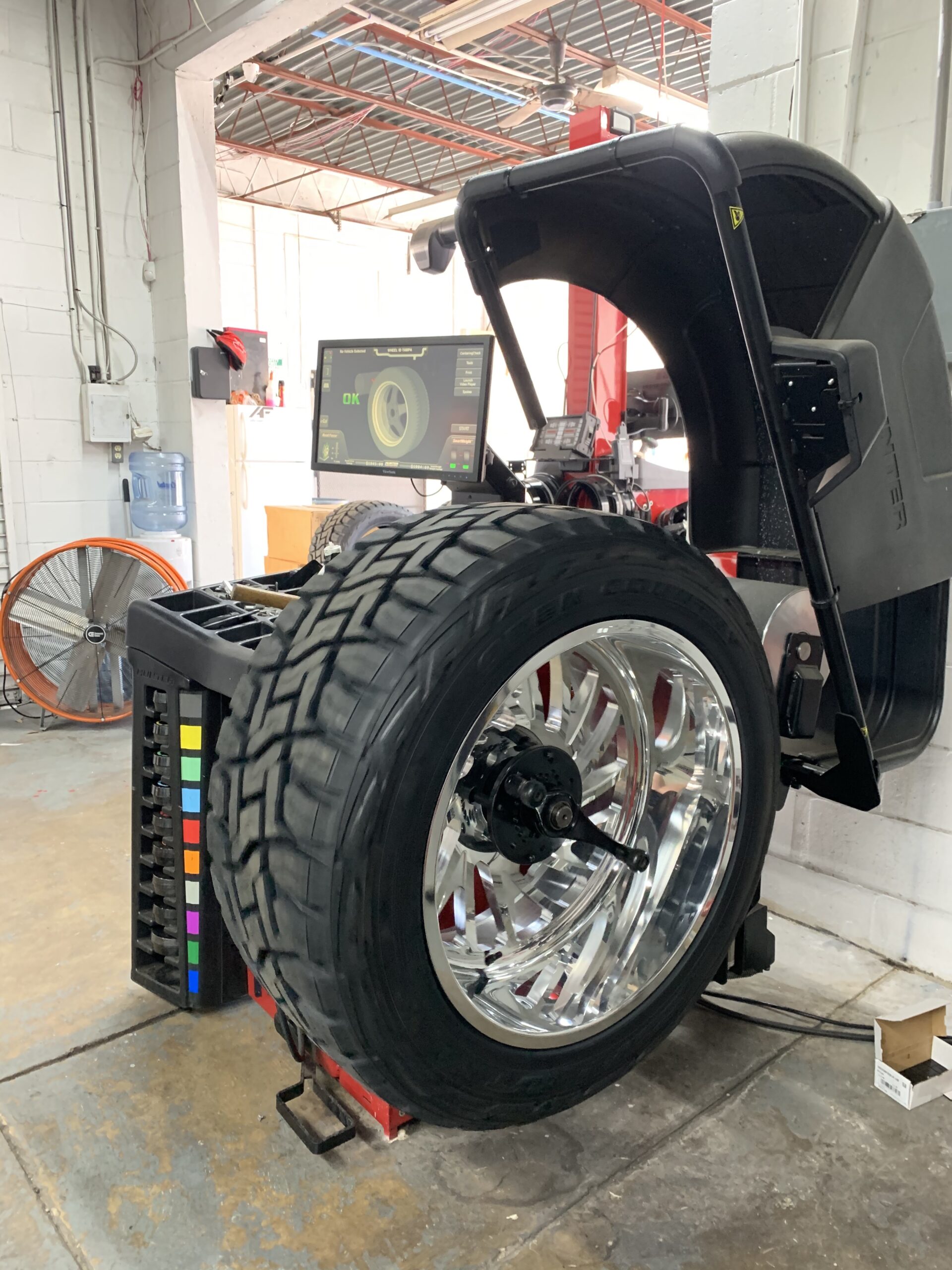 Wheel Identity balancing a tire on a machine for proper alignment and improved driving experience in Tampa, FL.